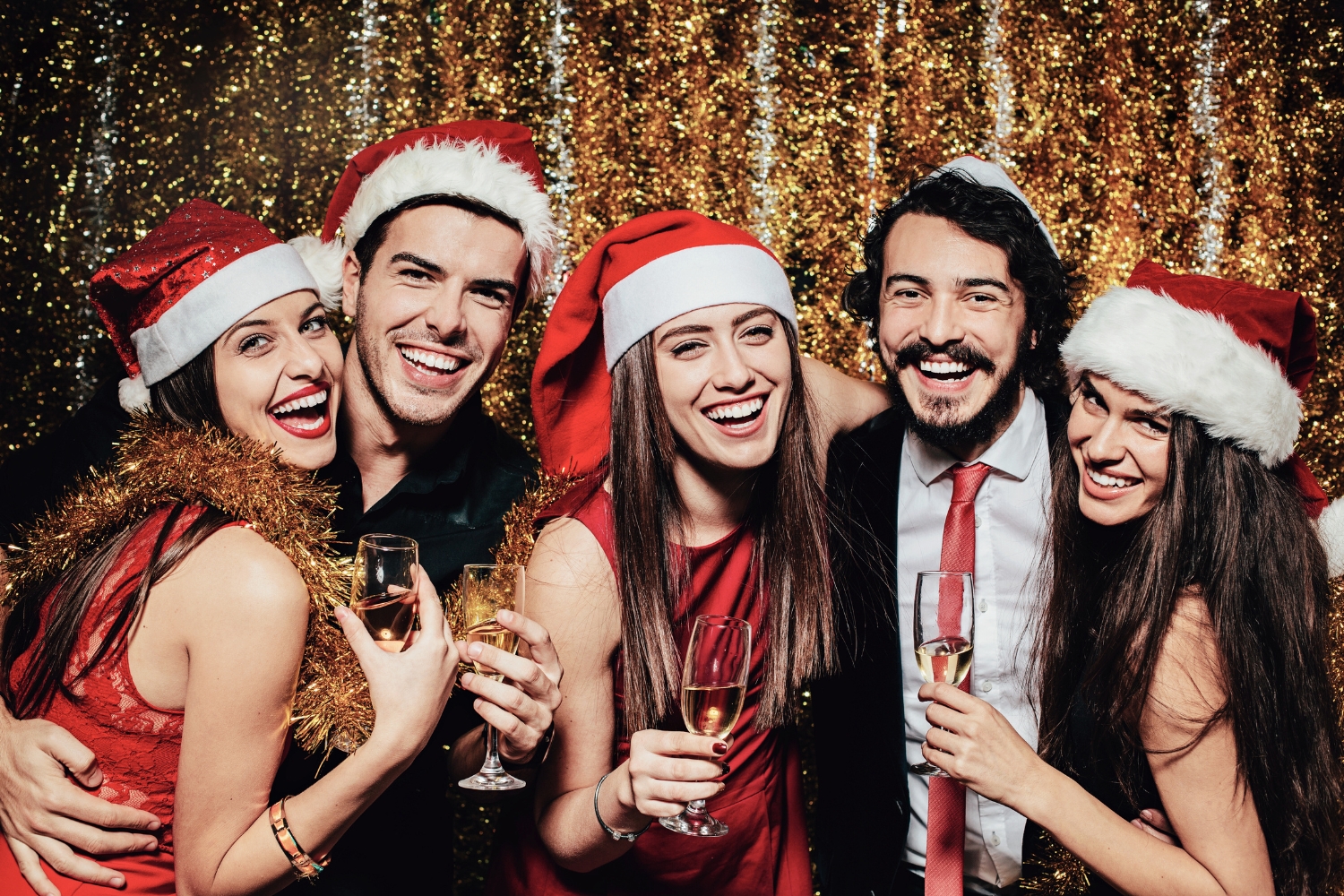 image of group of friends wearing Christmas hats and laughing