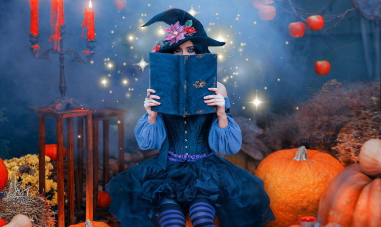 picture of a woman dressed as a pretty witch reading a spell boo